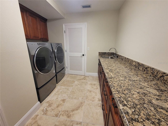8719 Kenmure Cv, Orlando, FL 32836 - washroom featuring separate washer and dryer, baseboards, light stone finish floors, cabinet space, and bar with sink