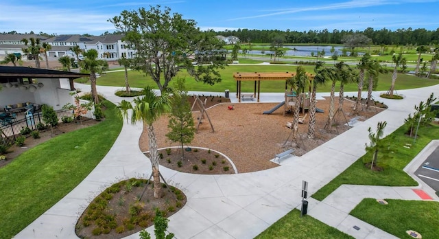 view of property's community with a water view, a lawn, and view of golf course