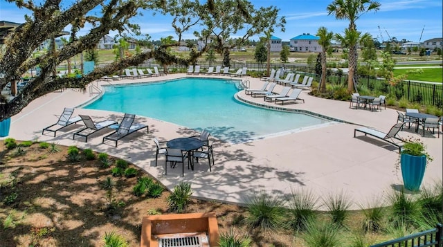 community pool featuring fence and a patio