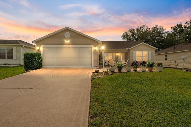 ranch-style house featuring driveway, a front yard, and an attached garage
