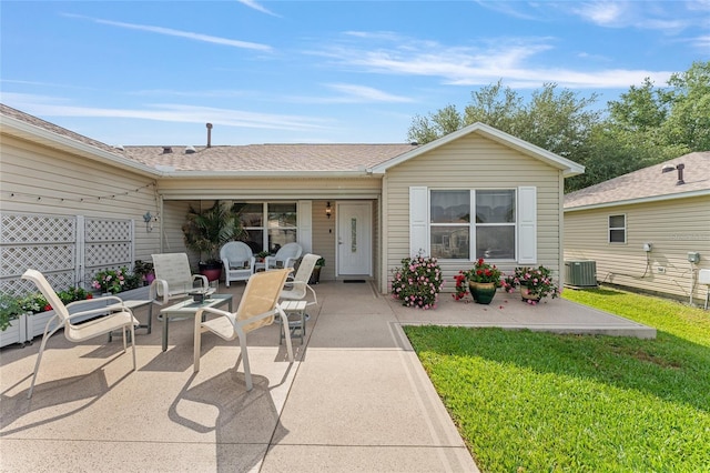 view of front of home featuring a patio, cooling unit, and a front yard