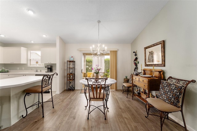 dining area with a chandelier, light wood-style flooring, baseboards, and recessed lighting