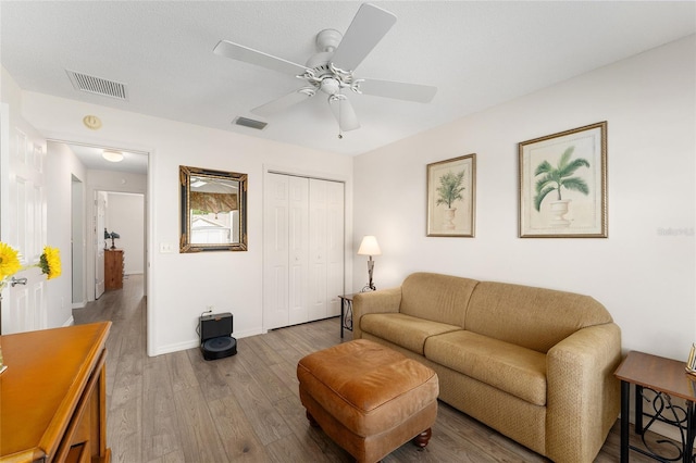 living room featuring wood finished floors, ceiling fan, and baseboards