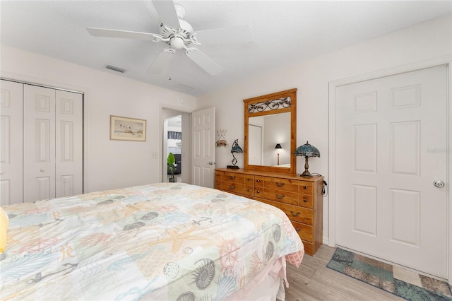 bedroom with light wood-style floors, a closet, and ceiling fan