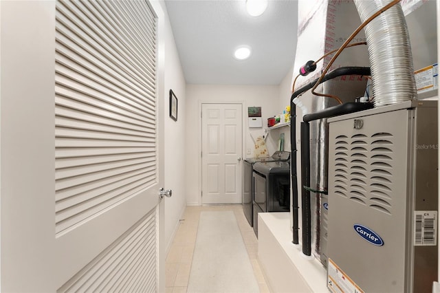 laundry room with washer and clothes dryer, heating unit, light tile patterned floors, and baseboards