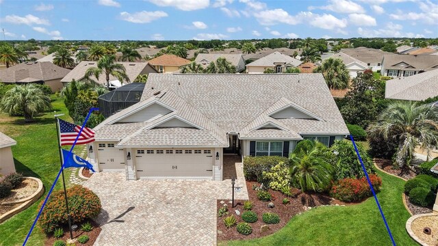 1053 Alcove Loop, The Villages, FL 32162 - view of front of home with a residential view, an attached garage, driveway, a front yard, and roof with shingles