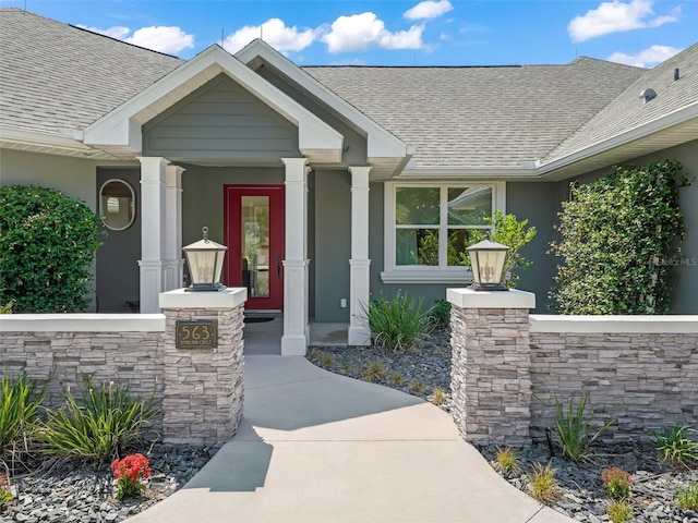 563 Dowling Cir, Lady Lake, FL 32159 - doorway to property featuring roof with shingles, stucco siding, a porch, and stone siding