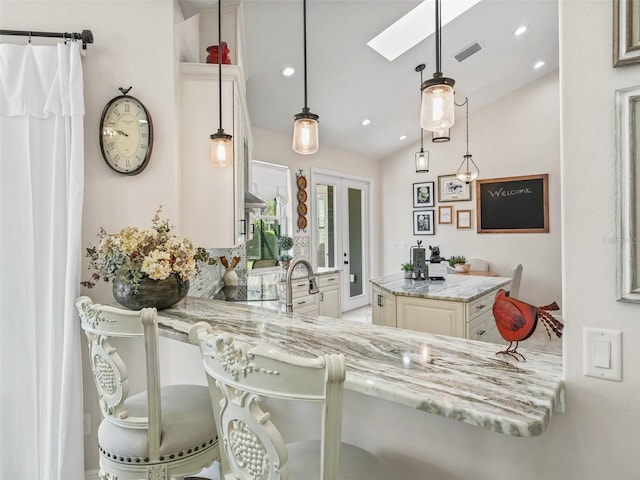 563 Dowling Cir, Lady Lake, FL 32159 - kitchen with vaulted ceiling, recessed lighting, light stone countertops, decorative light fixtures, and a skylight