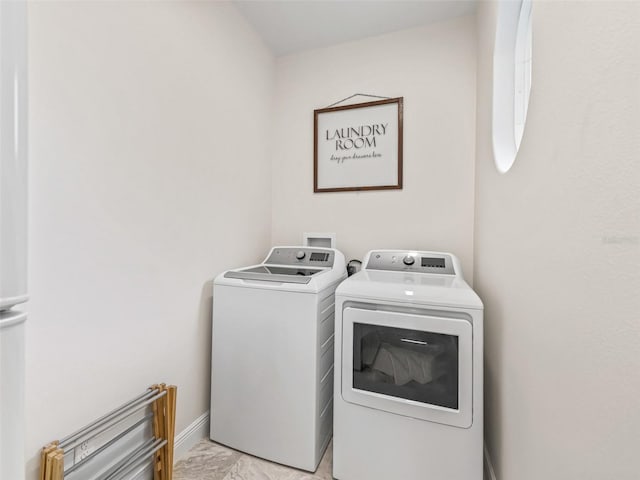 563 Dowling Cir, Lady Lake, FL 32159 - clothes washing area with washing machine and dryer, baseboards, and light marble finish flooring