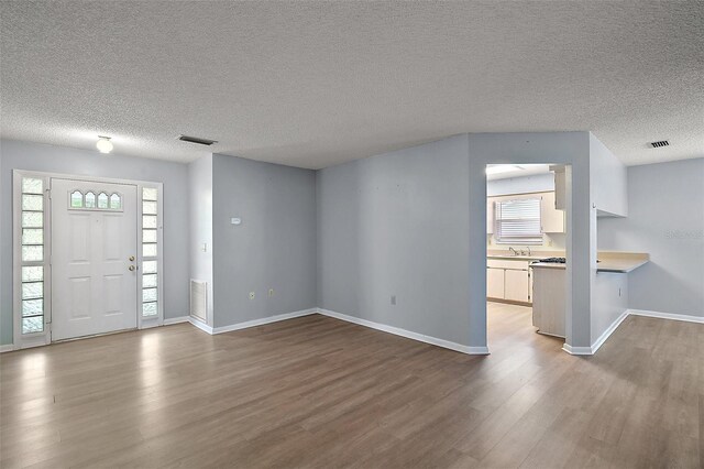5618 Rosewall Cir, Leesburg, FL 34748 - foyer entrance featuring wood finished floors, baseboards, and a textured ceiling
