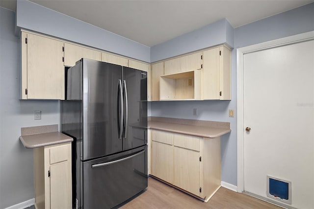 5618 Rosewall Cir, Leesburg, FL 34748 - kitchen with freestanding refrigerator, light wood-style floors, light countertops, light brown cabinets, and baseboards