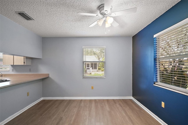 5618 Rosewall Cir, Leesburg, FL 34748 - unfurnished dining area with wood finished floors, a textured ceiling, a ceiling fan, and baseboards