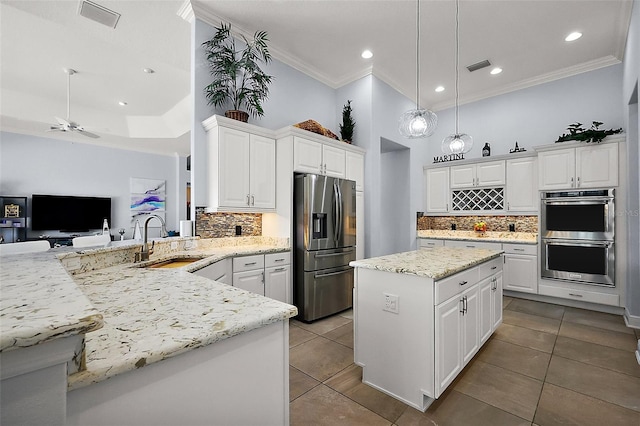 4033 Swaying Palm Ct, The Villages, FL 32163 - kitchen with stainless steel appliances, a sink, ornamental molding, decorative backsplash, and open floor plan