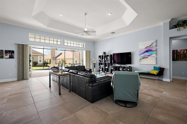 4033 Swaying Palm Ct, The Villages, FL 32163 - living area with ceiling fan, a raised ceiling, tile patterned flooring, crown molding, and baseboards