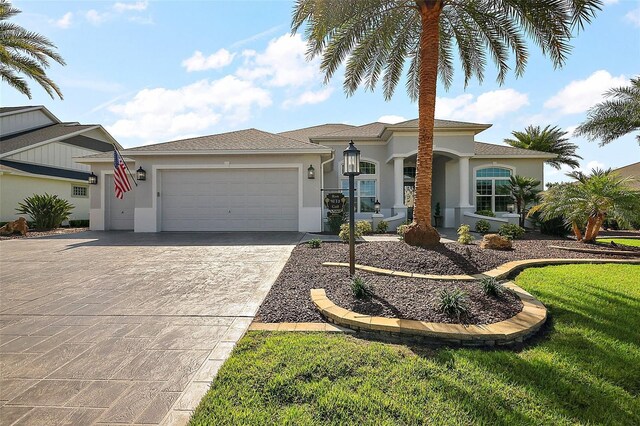 4033 Swaying Palm Ct, The Villages, FL 32163 - view of front of property with stucco siding, an attached garage, driveway, and a front yard