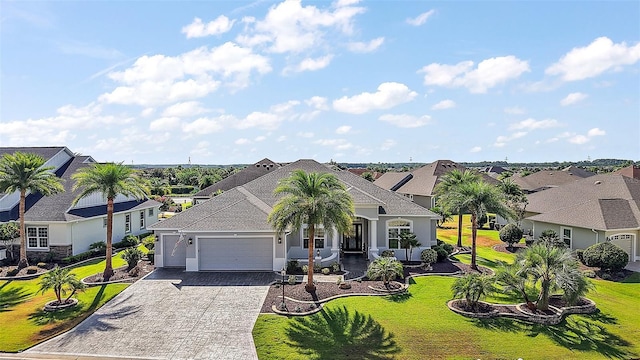 4033 Swaying Palm Ct, The Villages, FL 32163 - view of front of home featuring an attached garage, decorative driveway, a residential view, a front lawn, and stucco siding