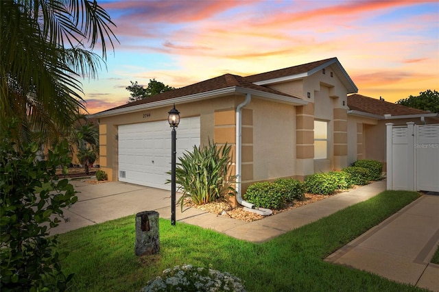 2744 Gresham Ave, The Villages, FL 32162 - property exterior at dusk featuring stucco siding, an attached garage, and driveway
