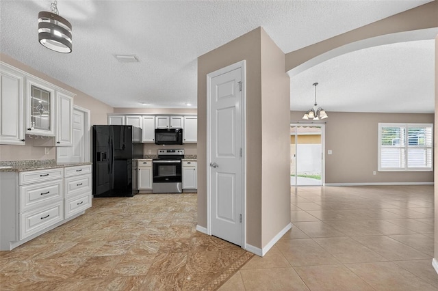 2744 Gresham Ave, The Villages, FL 32162 - kitchen featuring black appliances, a textured ceiling, white cabinetry, a chandelier, and light tile patterned floors