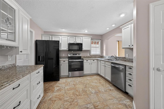 2744 Gresham Ave, The Villages, FL 32162 - kitchen with black appliances, arched walkways, a sink, a textured ceiling, and light stone counters