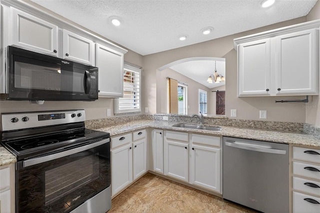 2744 Gresham Ave, The Villages, FL 32162 - kitchen with appliances with stainless steel finishes, a sink, a chandelier, arched walkways, and a textured ceiling
