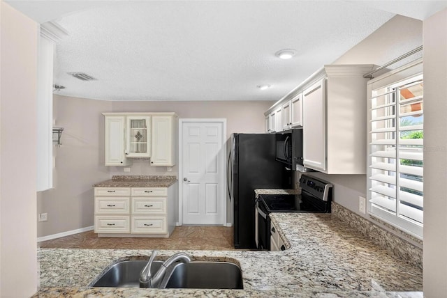 2744 Gresham Ave, The Villages, FL 32162 - kitchen featuring stainless steel range with electric stovetop, a sink, black microwave, glass insert cabinets, and a textured ceiling
