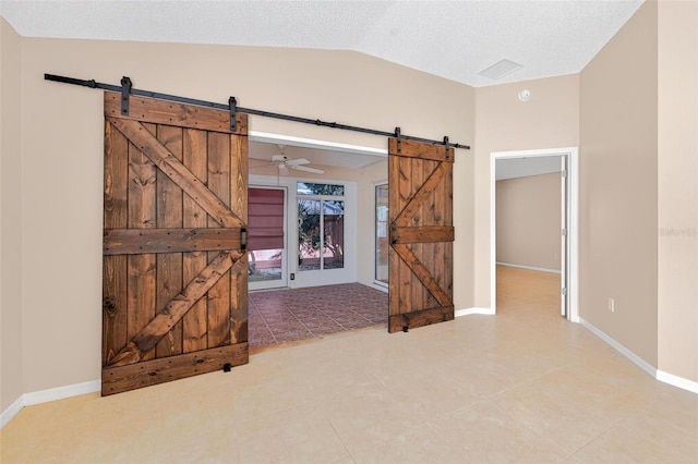 2744 Gresham Ave, The Villages, FL 32162 - unfurnished room featuring a barn door, light tile patterned floors, lofted ceiling, baseboards, and a textured ceiling
