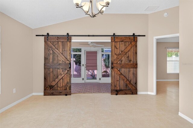 2744 Gresham Ave, The Villages, FL 32162 - spare room with a barn door, vaulted ceiling, a chandelier, tile patterned flooring, and baseboards