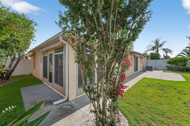 2744 Gresham Ave, The Villages, FL 32162 - rear view of property with central AC unit, stucco siding, a patio area, and a gate