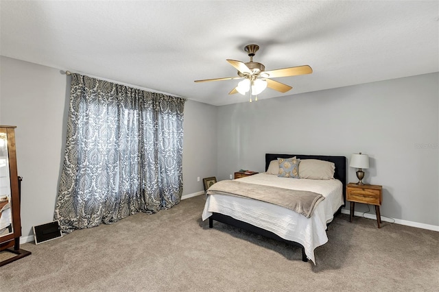 carpeted bedroom with ceiling fan and baseboards