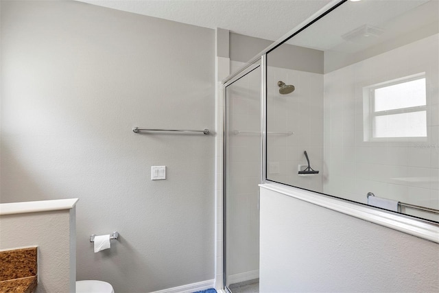 full bathroom featuring tiled shower and toilet