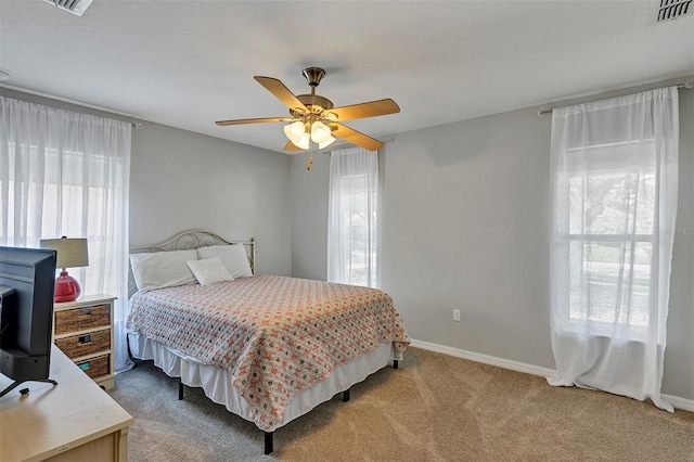 bedroom featuring multiple windows, carpet floors, ceiling fan, and baseboards