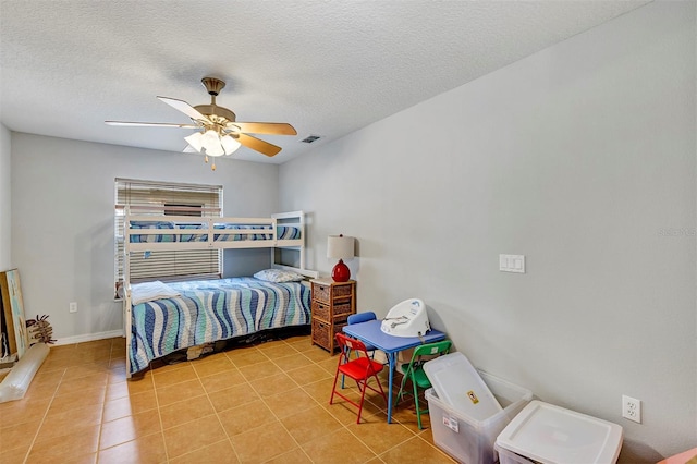 tiled bedroom featuring a textured ceiling, ceiling fan, and baseboards