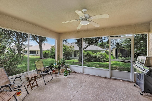 sunroom / solarium featuring a ceiling fan