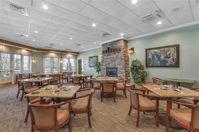 dining room with ornamental molding, carpet floors, and a fireplace