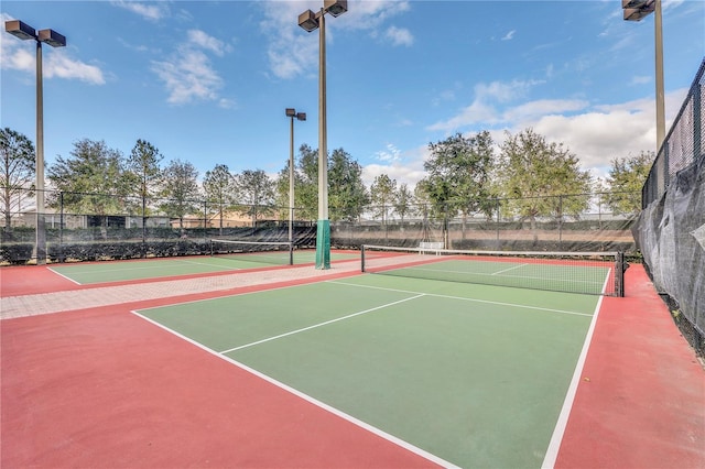 view of tennis court featuring community basketball court and fence