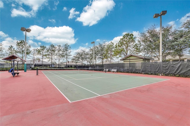 view of tennis court with community basketball court and fence
