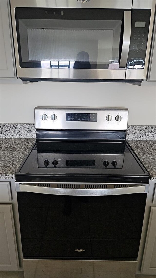 2106 Elio Ridge Dr, Zellwood, FL 32798 - kitchen view of appliances with stainless steel finishes and dark stone countertops