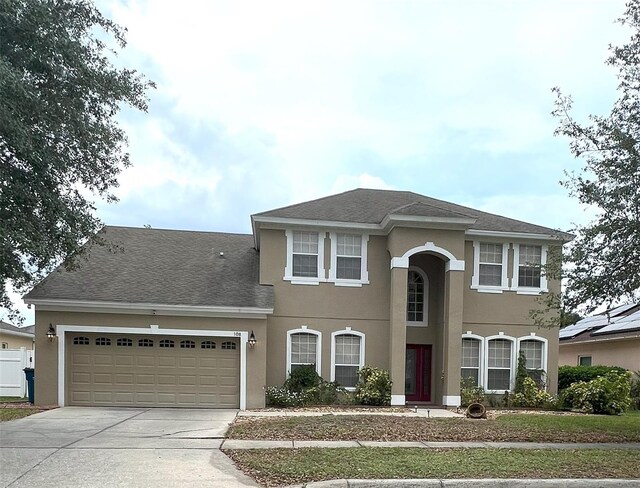 108 Whispering Pines Way, Davenport, FL 33837 - view of front of home featuring stucco siding, a garage, driveway, and roof with shingles