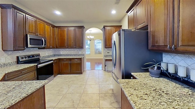 108 Whispering Pines Way, Davenport, FL 33837 - kitchen with appliances with stainless steel finishes, arched walkways, backsplash, a chandelier, and recessed lighting