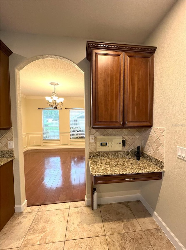 108 Whispering Pines Way, Davenport, FL 33837 - interior space featuring arched walkways, tasteful backsplash, a chandelier, and baseboards