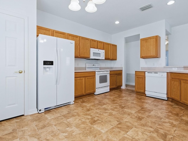 8601 SE 133rd St, Summerfield, FL 34491 - kitchen with white appliances, light countertops, brown cabinetry, and recessed lighting