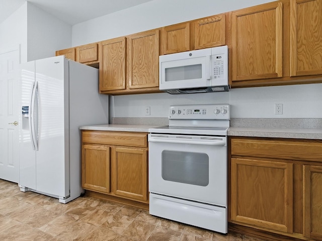 8601 SE 133rd St, Summerfield, FL 34491 - kitchen with white appliances, light countertops, and brown cabinetry