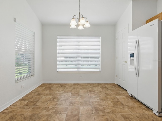 8601 SE 133rd St, Summerfield, FL 34491 - unfurnished dining area featuring a chandelier, stone finish flooring, and baseboards