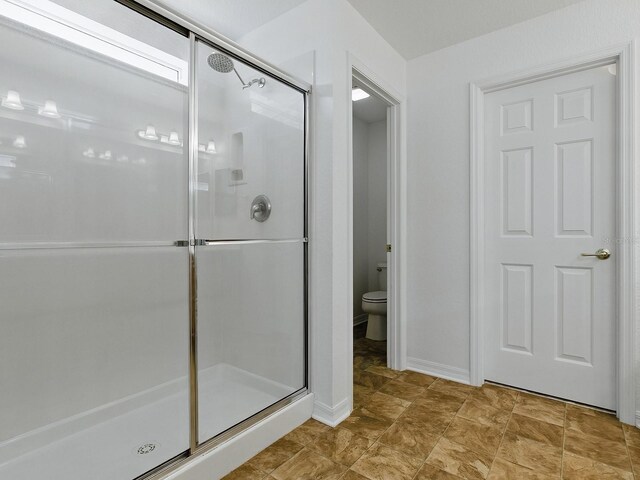 8601 SE 133rd St, Summerfield, FL 34491 - full bath featuring a shower stall, toilet, and baseboards