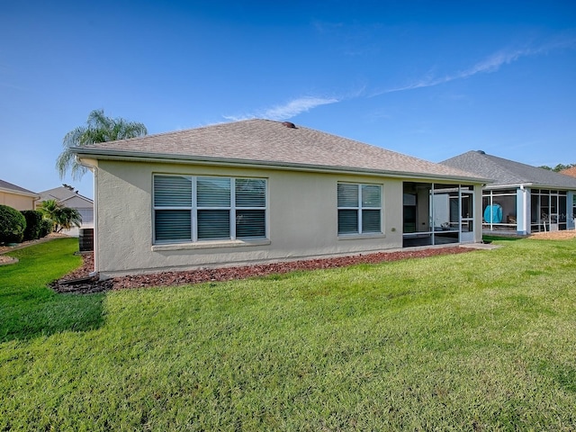 8601 SE 133rd St, Summerfield, FL 34491 - rear view of property featuring a sunroom, a yard, stucco siding, and roof with shingles