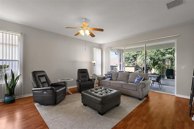 5604 Gulf Stream St, Tavares, FL 32778 - living area featuring wood finished floors, ceiling fan, plenty of natural light, and baseboards