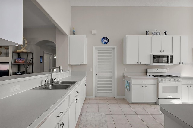 5604 Gulf Stream St, Tavares, FL 32778 - kitchen featuring white gas stove, a sink, arched walkways, baseboards, and light countertops