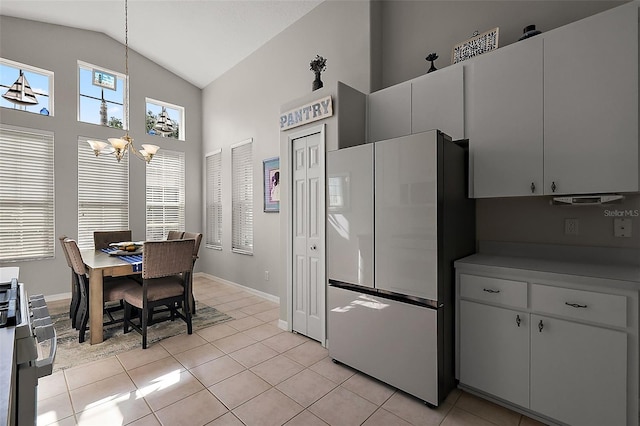5604 Gulf Stream St, Tavares, FL 32778 - kitchen featuring freestanding refrigerator, a chandelier, light tile patterned floors, high vaulted ceiling, and baseboards