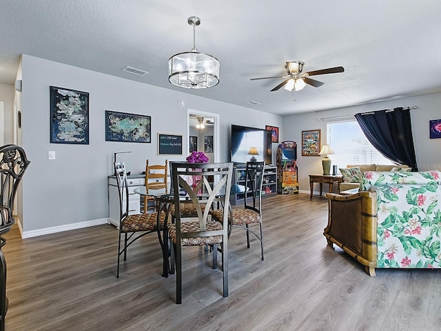 1722 Moreno Pl, The Villages, FL 32159 - dining area featuring ceiling fan, wood finished floors, a chandelier, baseboards, and a textured ceiling