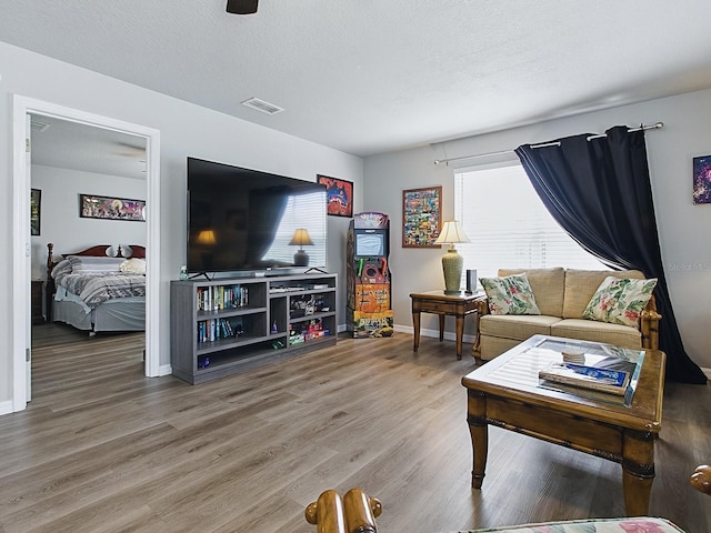 1722 Moreno Pl, The Villages, FL 32159 - living room featuring wood finished floors, baseboards, and a textured ceiling